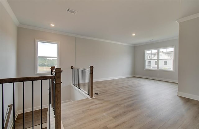 empty room with recessed lighting, wood finished floors, visible vents, baseboards, and crown molding