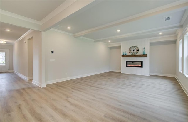 unfurnished living room featuring light wood-style floors, beam ceiling, a fireplace, and crown molding