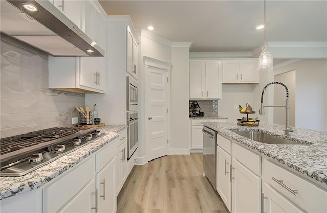 kitchen featuring stainless steel appliances, light wood-style floors, white cabinetry, a sink, and under cabinet range hood