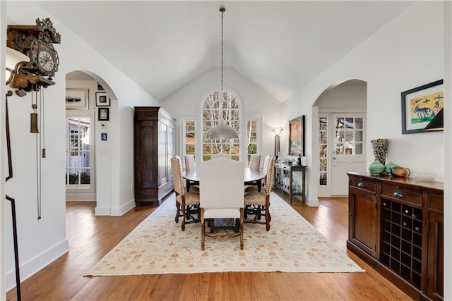 dining room with hardwood / wood-style flooring and vaulted ceiling