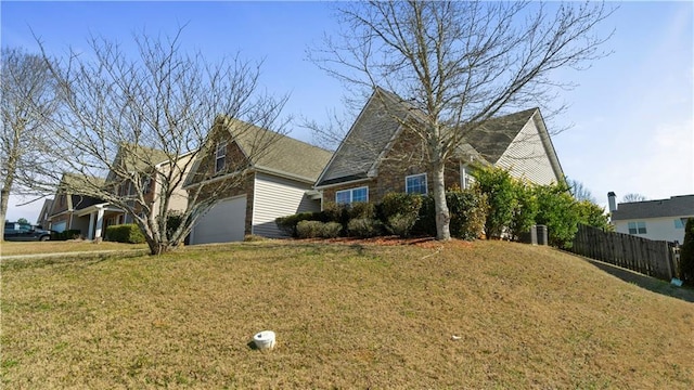 view of front of property with a garage, a front lawn, and fence