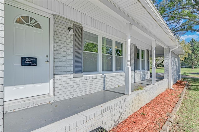 view of exterior entry featuring covered porch