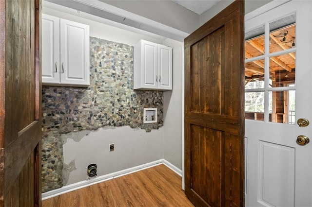 laundry room with hookup for a washing machine, wood finished floors, baseboards, cabinet space, and electric dryer hookup