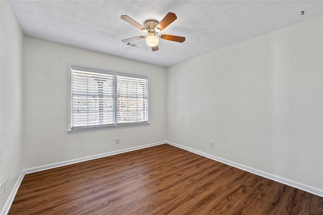 spare room with ceiling fan, baseboards, and dark wood-style flooring