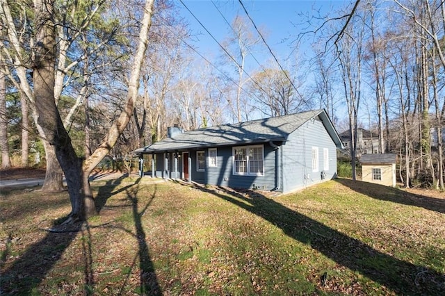 ranch-style house with a chimney and a front lawn