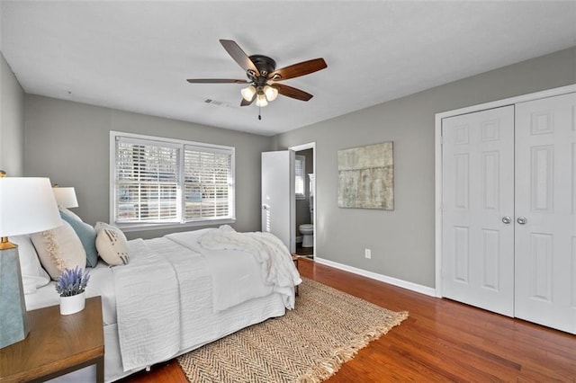 bedroom with a closet, visible vents, a ceiling fan, wood finished floors, and baseboards