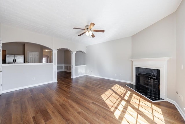 2873 Snapfinger Mnr, Decatur, GA 30035 - unfurnished living room with arched walkways, a ceiling fan, decorative columns, wood finished floors, and a fireplace