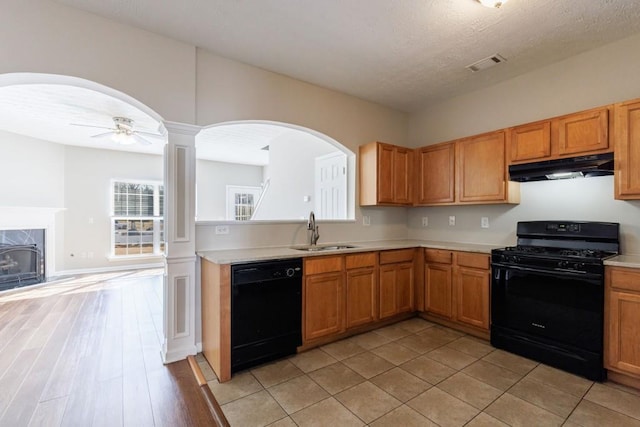 2873 Snapfinger Mnr, Decatur, GA 30035 - kitchen with black appliances, under cabinet range hood, light countertops, a ceiling fan, and a high end fireplace