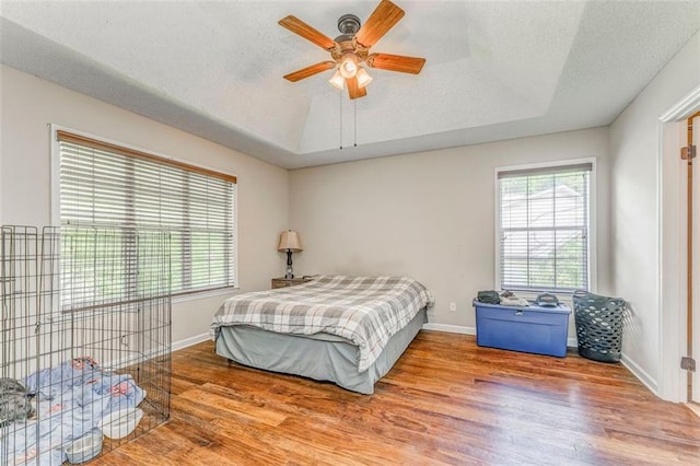 200 Wildwood Cir SE, Calhoun, GA 30701 - bedroom with wood finished floors, a tray ceiling, baseboards, a textured ceiling, and ceiling fan