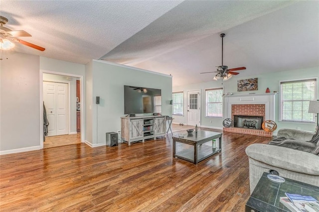 200 Wildwood Cir SE, Calhoun, GA 30701 - living area featuring a ceiling fan, wood finished floors, a brick fireplace, a textured ceiling, and baseboards