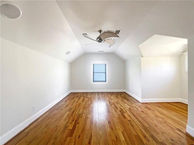 full bathroom with baseboards, a shower stall, a bath, and wood finished floors