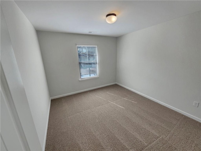 empty room featuring visible vents, baseboards, and carpet flooring