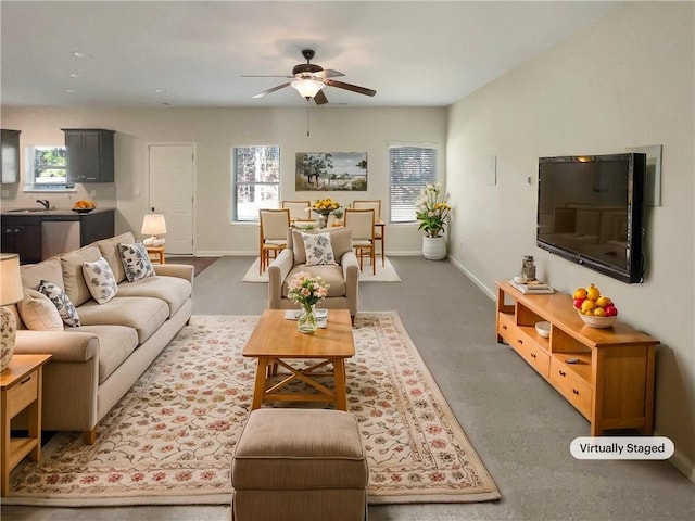 living room featuring baseboards and a ceiling fan