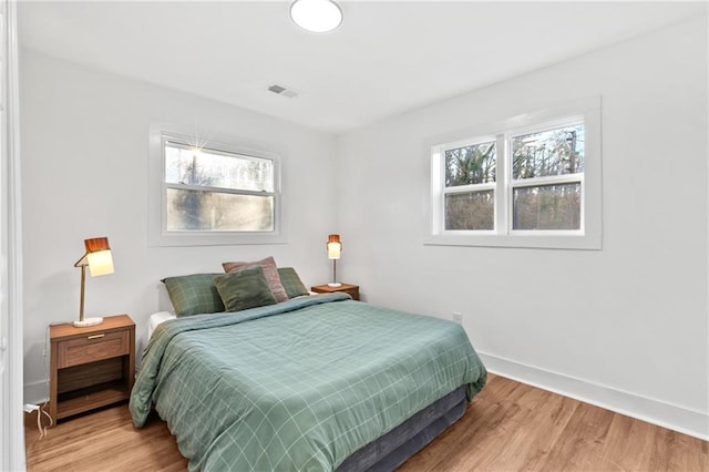 bedroom featuring multiple windows and light hardwood / wood-style floors