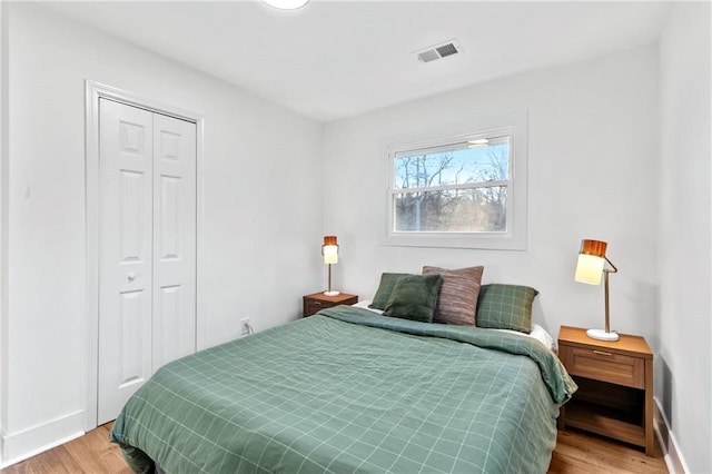 bedroom with light wood-type flooring and a closet