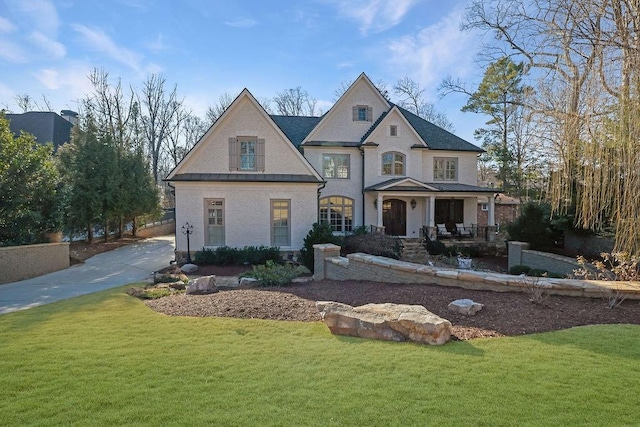 view of front of property featuring brick siding and a front yard