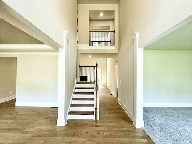 237 Lotus Ln, Covington, GA 30016 - staircase featuring a towering ceiling and wood finished floors