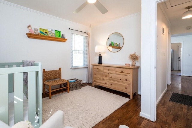 bedroom with crown molding, baseboards, and wood finished floors