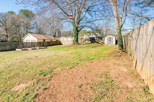 view of yard with an outbuilding, a fenced backyard, and a storage shed