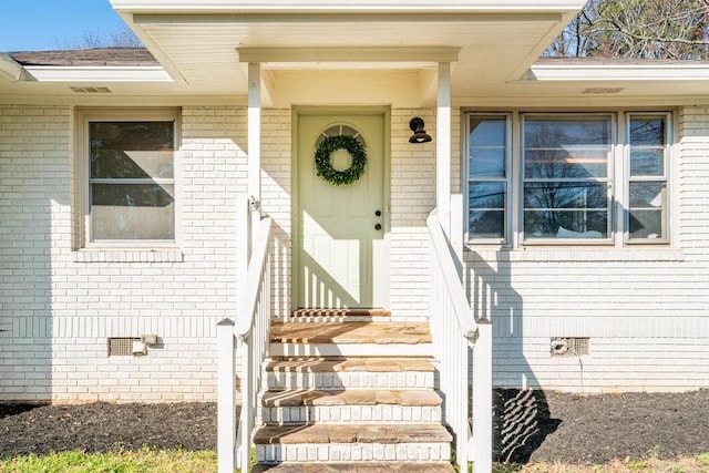 doorway to property with crawl space and brick siding