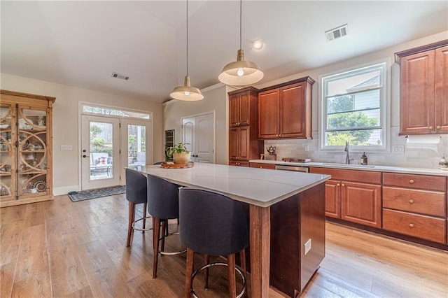 kitchen featuring a sink, light wood-style flooring, light countertops, and a kitchen island
