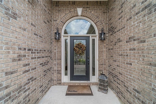 view of exterior entry with brick siding