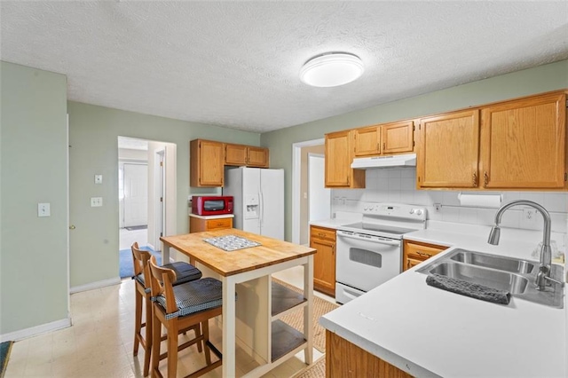 kitchen featuring a textured ceiling, decorative backsplash, sink, and white appliances