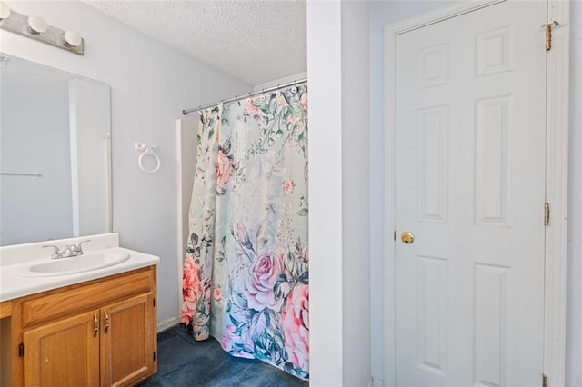 bathroom featuring a shower with curtain, vanity, and a textured ceiling