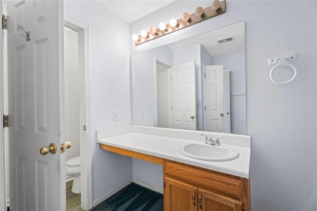 bathroom featuring vanity and toilet