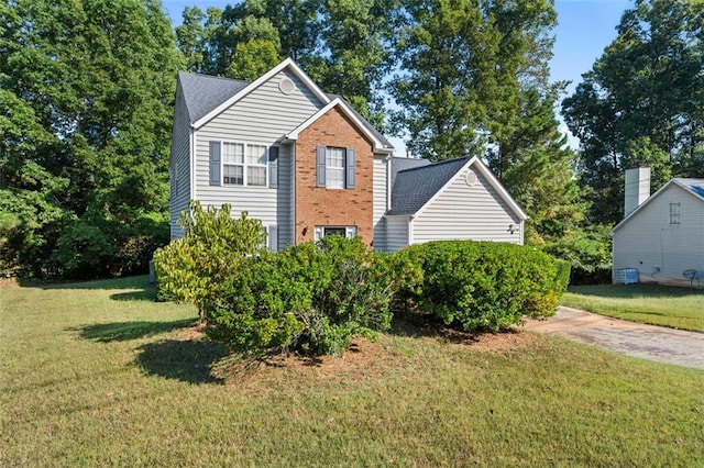 view of side of property featuring central AC unit and a yard