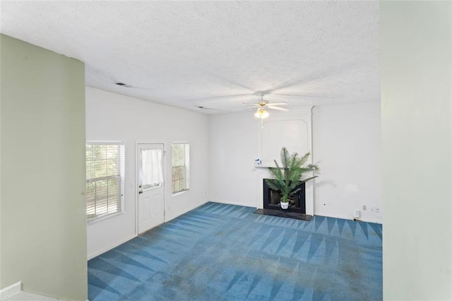 foyer with lofted ceiling, carpet floors, a textured ceiling, and ceiling fan