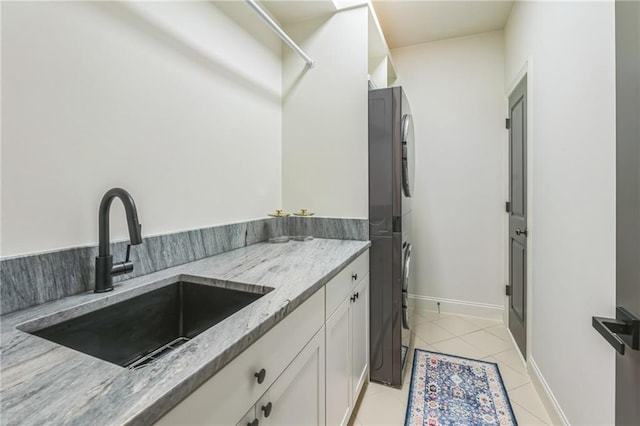 2313 Saint Davids Sq NW Unit 12, Kennesaw, GA 30152 - laundry area with stacked washer and clothes dryer, light tile patterned flooring, cabinet space, and baseboards
