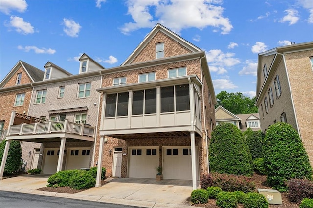 2313 Saint Davids Sq NW Unit 12, Kennesaw, GA 30152 - view of front of home featuring brick siding, a garage, driveway, and a sunroom