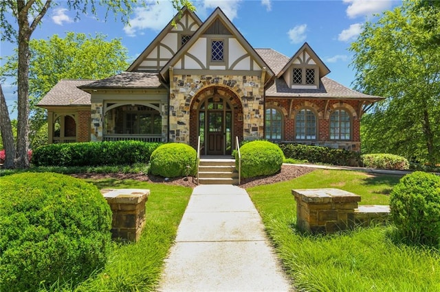 2313 Saint Davids Sq NW Unit 12, Kennesaw, GA 30152 - tudor house featuring stone siding, a front yard, and a shingled roof