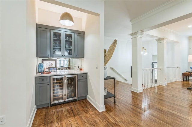 2313 Saint Davids Sq NW Unit 12, Kennesaw, GA 30152 - indoor dry bar with beverage cooler, dark wood-style floors, ornate columns, ornamental molding, and baseboards