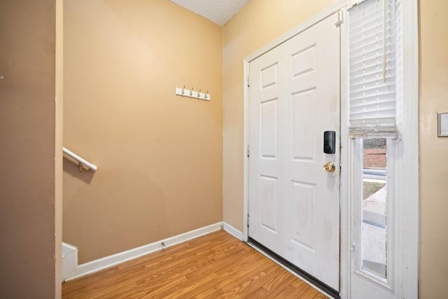 foyer with light wood-type flooring and baseboards