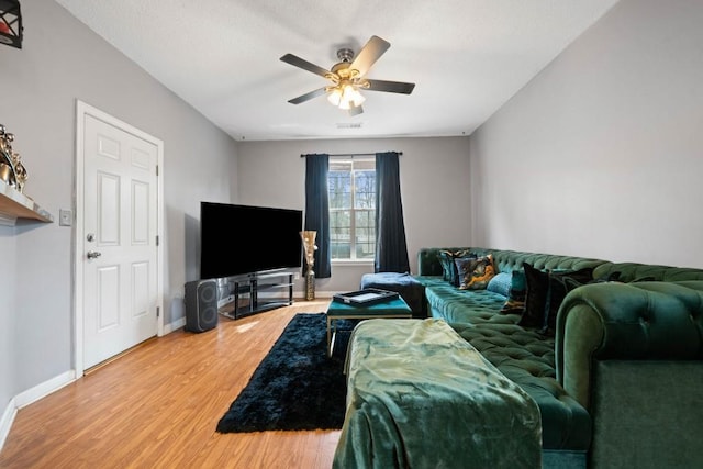 living area with ceiling fan, light wood-type flooring, visible vents, and baseboards