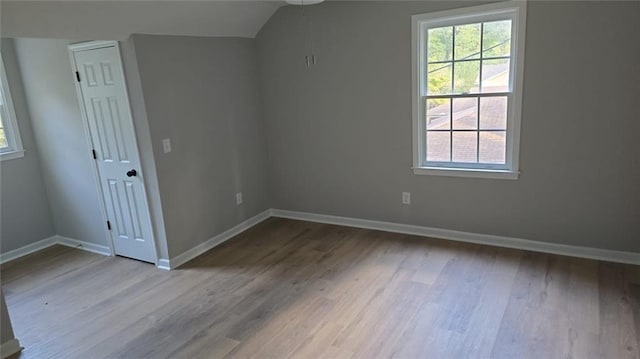 interior space with multiple windows, wood finished floors, and baseboards