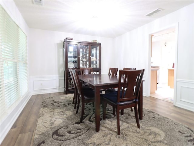 550 Sessingham Ct, Alpharetta, GA 30005 - dining area featuring wood finished floors, wainscoting, healthy amount of natural light, and a decorative wall
