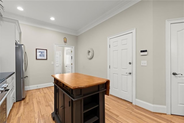 kitchen with ornamental molding, freestanding refrigerator, and light wood finished floors