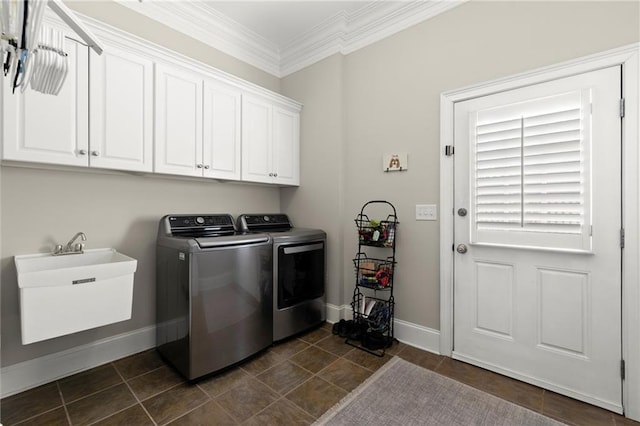 clothes washing area with cabinet space, ornamental molding, a sink, independent washer and dryer, and baseboards