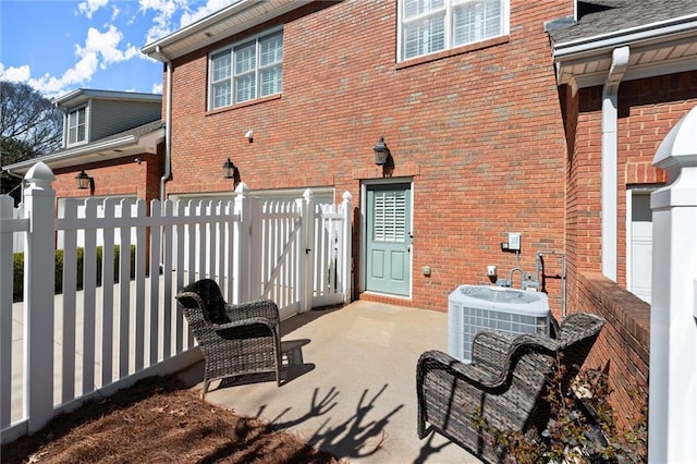 view of patio featuring central AC and fence