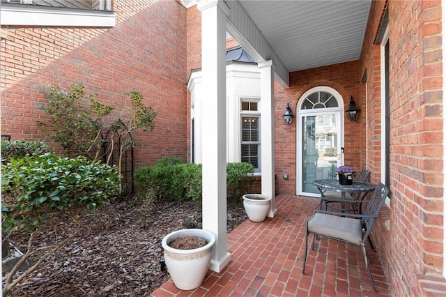 view of exterior entry featuring brick siding