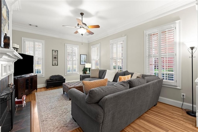 living area with plenty of natural light, visible vents, a fireplace with flush hearth, and ornamental molding