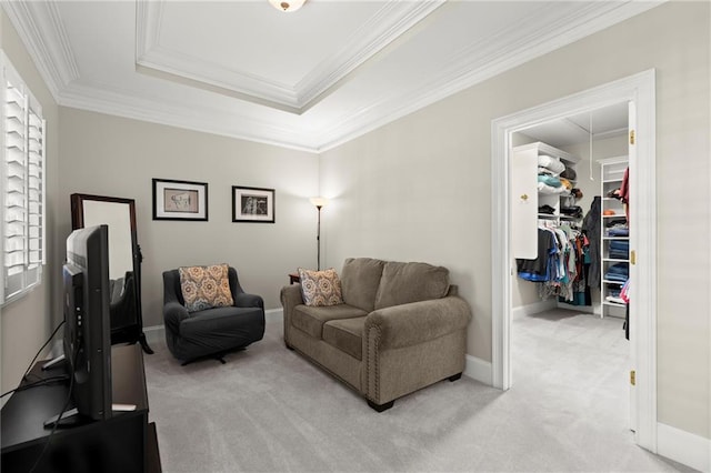 living area with light carpet, a tray ceiling, ornamental molding, and baseboards