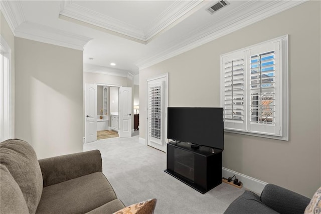 living room with carpet floors, a tray ceiling, plenty of natural light, and visible vents