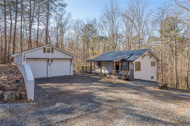 view of front of property with a garage, an outdoor structure, and a porch