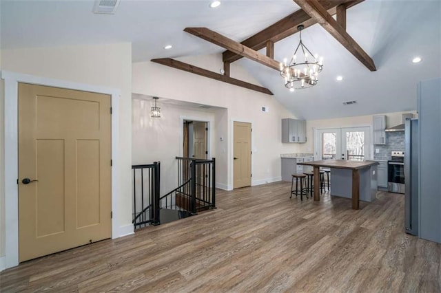 kitchen with hanging light fixtures, a kitchen island, gray cabinetry, and a kitchen breakfast bar