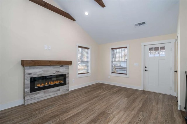 unfurnished living room featuring high vaulted ceiling and dark hardwood / wood-style floors