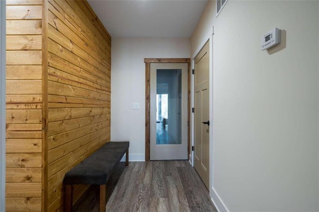 entryway featuring dark hardwood / wood-style floors and wood walls